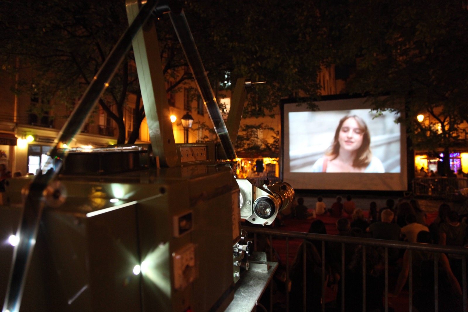 Proiezione cinematografica all'aperto su schermo gonfiabile Hallucine, con il proiettore in primo piano